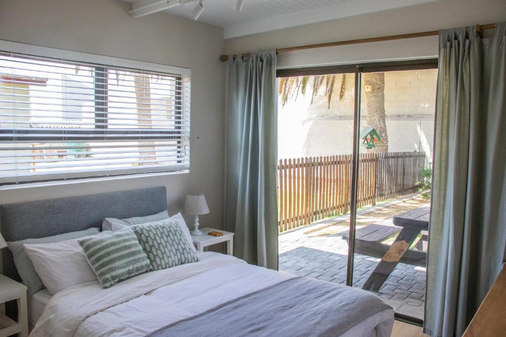 Schlafzimmer mit einem Bett und einer Glasschiebetür in der Unterkunft Avodation in Walvis Bay