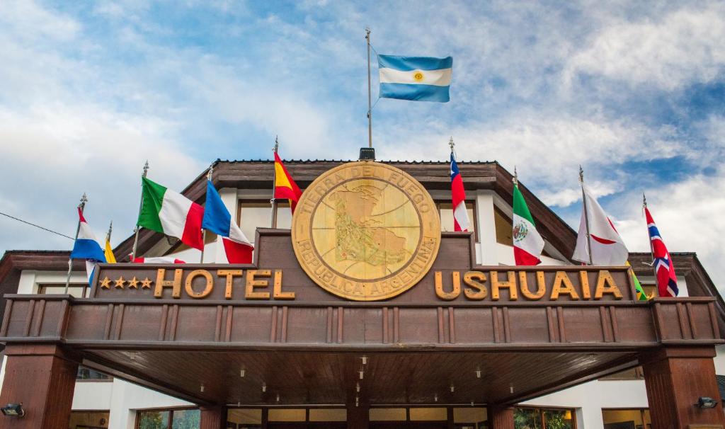 un hotel con un orologio e una bandiera sopra di Hotel Ushuaia a Ushuaia