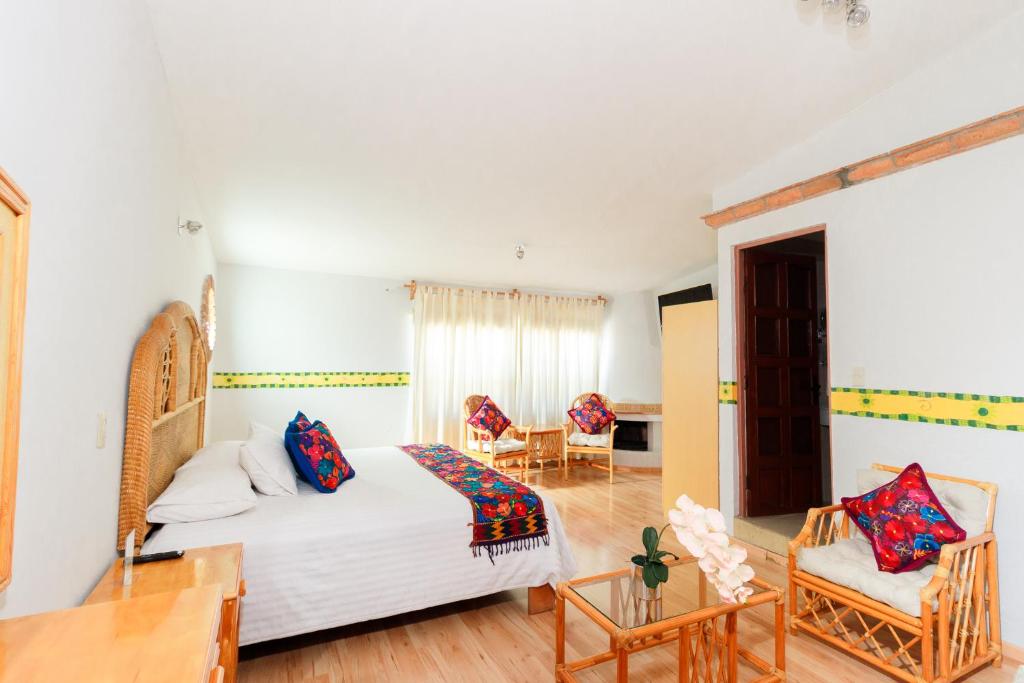 a bedroom with a bed and a table and chairs at Hotel Hacienda Montesinos in Morelia