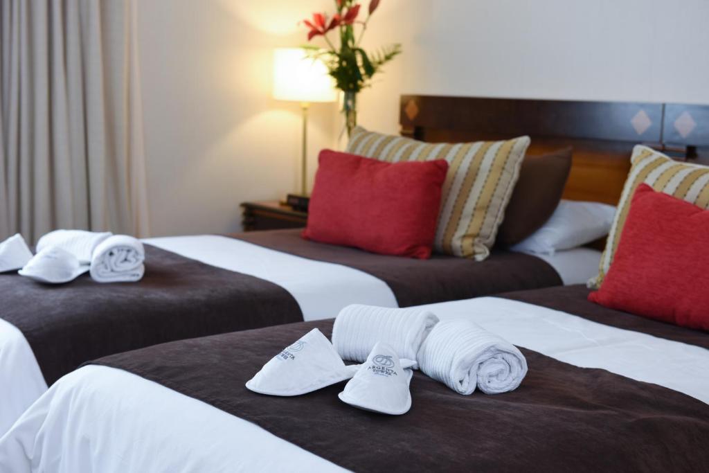 two beds in a hotel room with towels on them at Argenta Tower Hotel & Suites in Buenos Aires