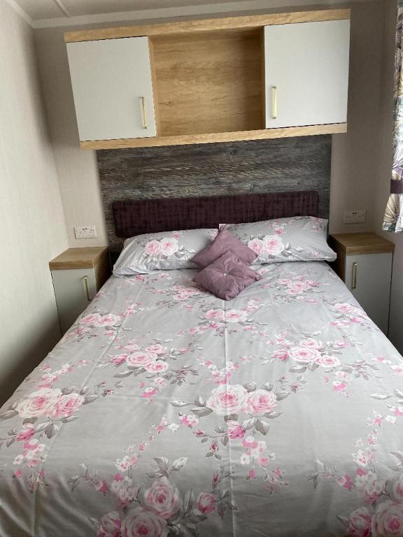 a bedroom with a bed with pink flowers on it at Swift Bordeaux in Dunoon