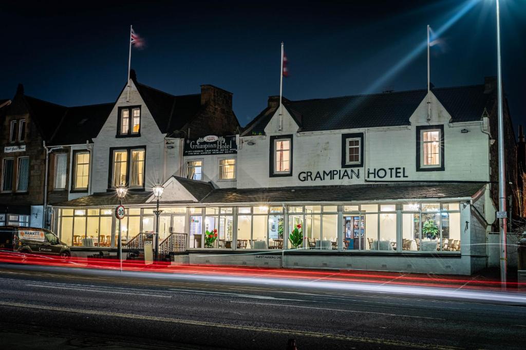 a building with a sign on the front of it at night at Grampian Hotel in Perth