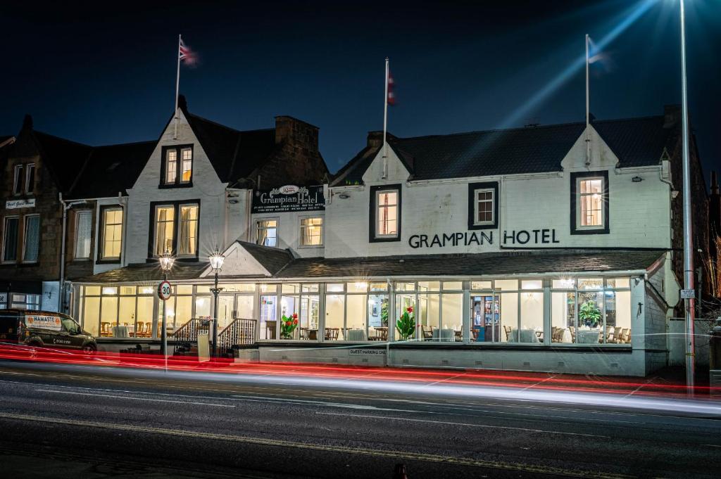 a building with a sign on the front of it at night at Grampian Hotel in Perth