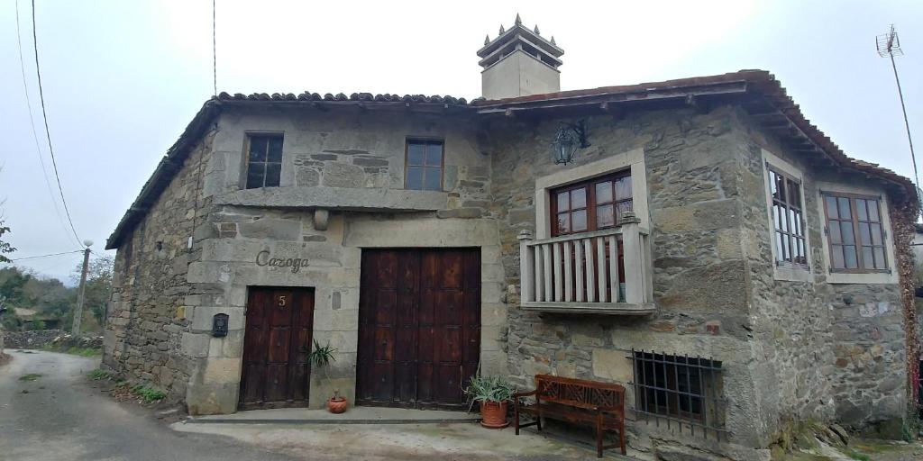 un antiguo edificio de piedra con dos puertas y una ventana en Viña Cazoga, en Sober