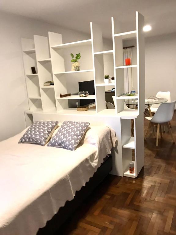 a bedroom with a bed with white shelves at Monoambiente Centro in Cordoba