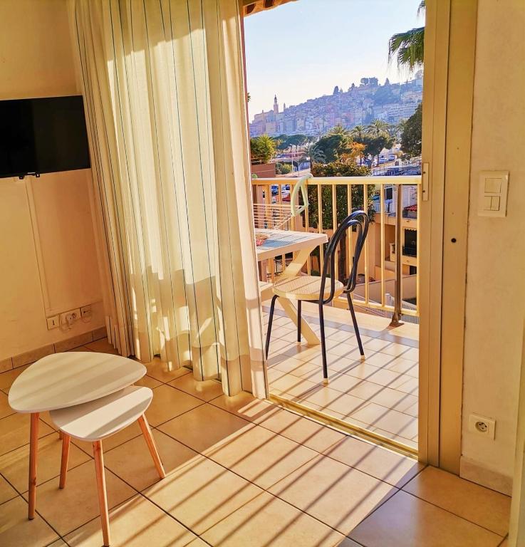 un balcon avec une table et des chaises et une vue dans l'établissement MENTON BORD DE MER Studio calme avec balcon, Ascenseur, Climatisation, Ideal location quiet near sea, balcony, elevator, AC, à Menton