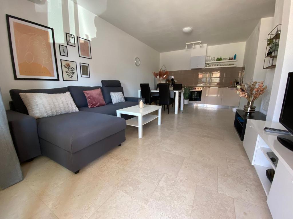 a living room with a blue couch and a table at HolidayHome Niko in Medulin