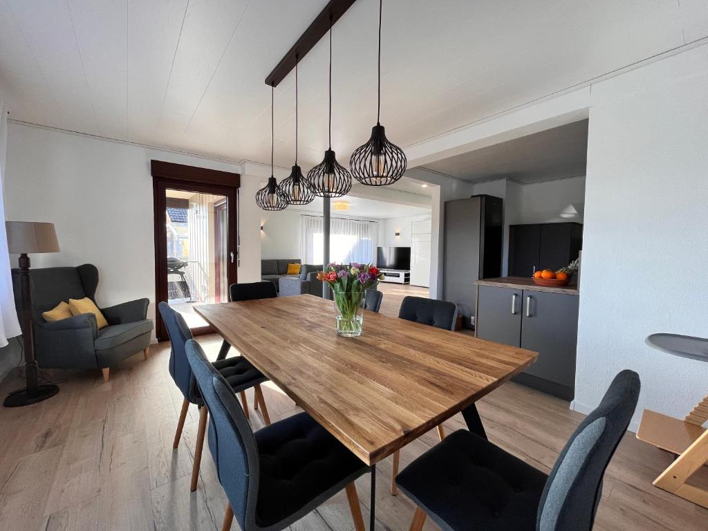 een eetkamer en een keuken met een houten tafel en stoelen bij Auszeit im Gartenweg in Neuweiler