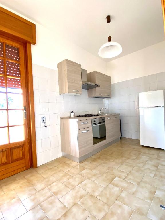 kuchnia z kuchenką i lodówką w obiekcie Appartamento "L'Ulivo" a Lido Marini w mieście Lido Marini