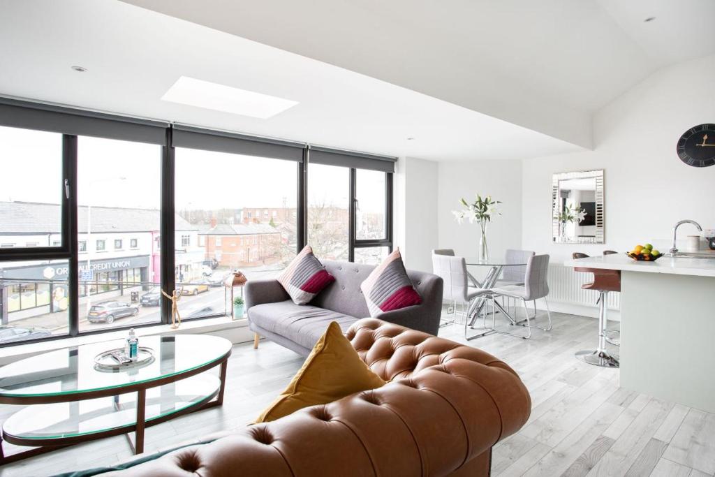 uma sala de estar com um sofá e uma mesa em Fabulous Penthouse, Brilliant Location, Sleeps 6! em Belfast