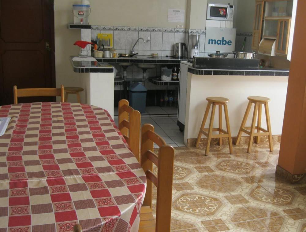 cocina con mesa y taburetes en Travelershouse Casa Hospedaje, en Huanchaco