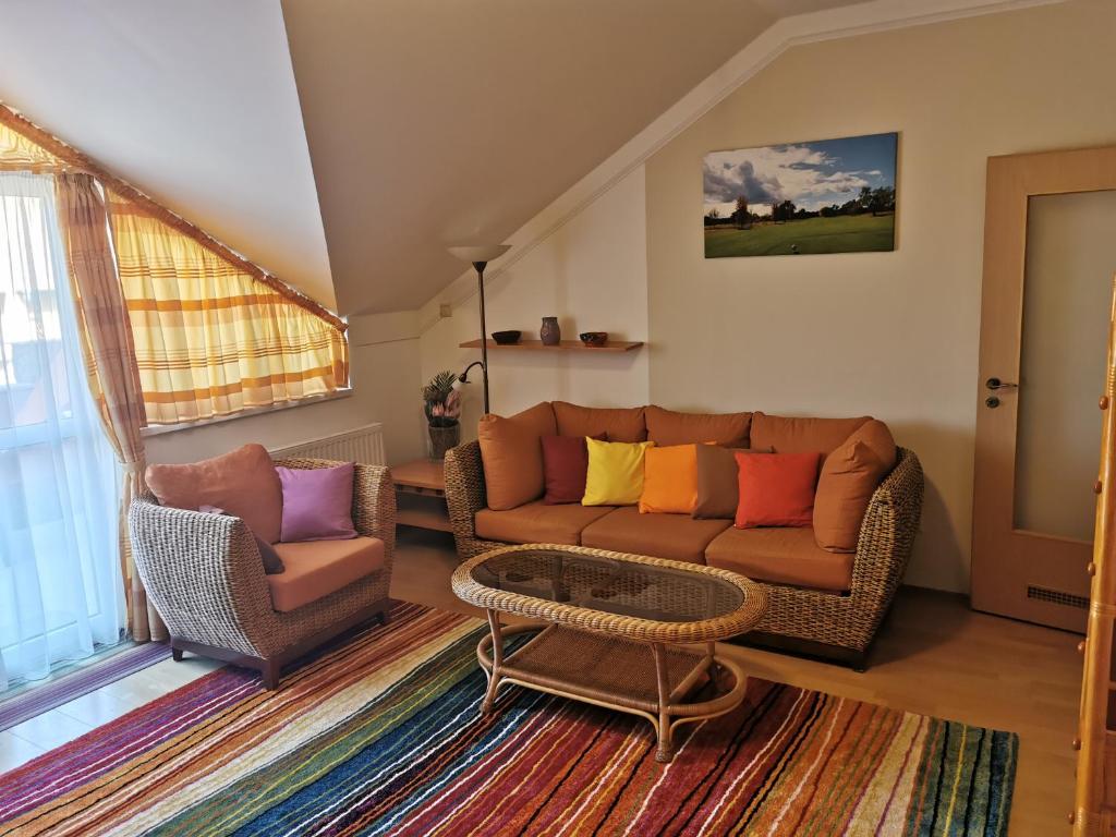 sala de estar con sofá y 2 sillas en Best Golf-Birdland Apartman en Bük