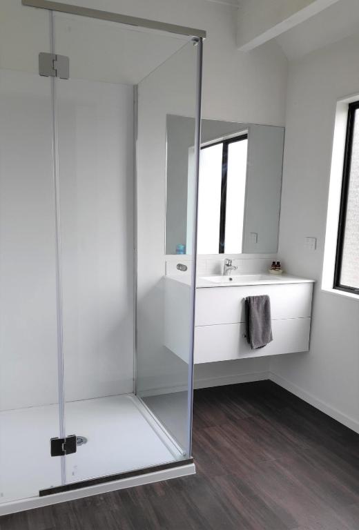 a bathroom with a glass shower and a sink at Drury Motor Lodge in Drury