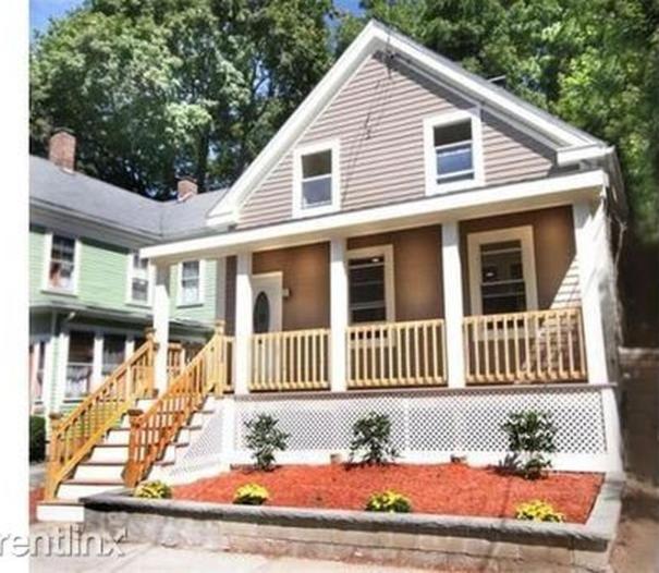 uma pequena casa branca com um alpendre e escadas em Boston's Best Vacation House em Boston