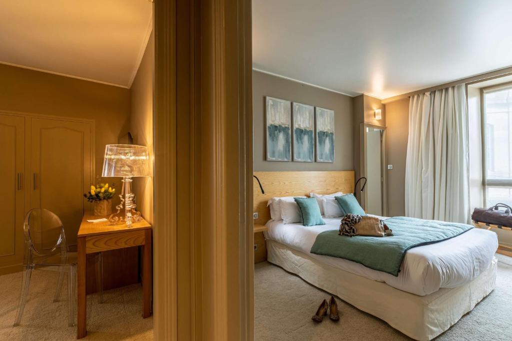 a bedroom with a bed and a desk and a window at Best Western Grand Hotel de Bordeaux in Aurillac