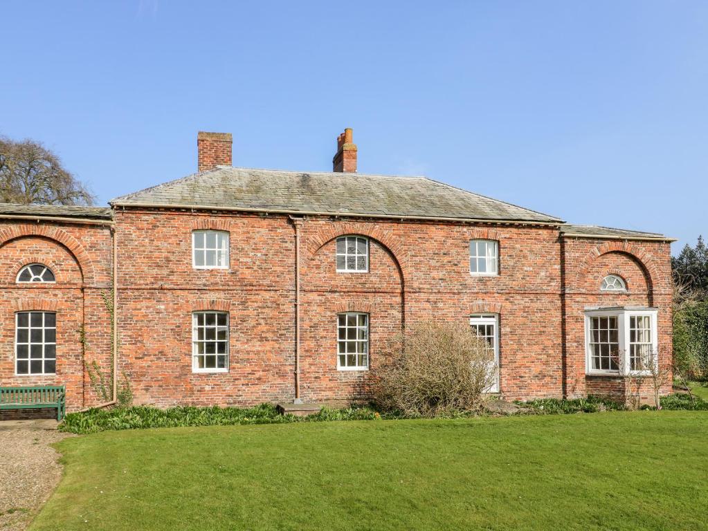 an old brick house with a green lawn at Carr Cottage in Boynton