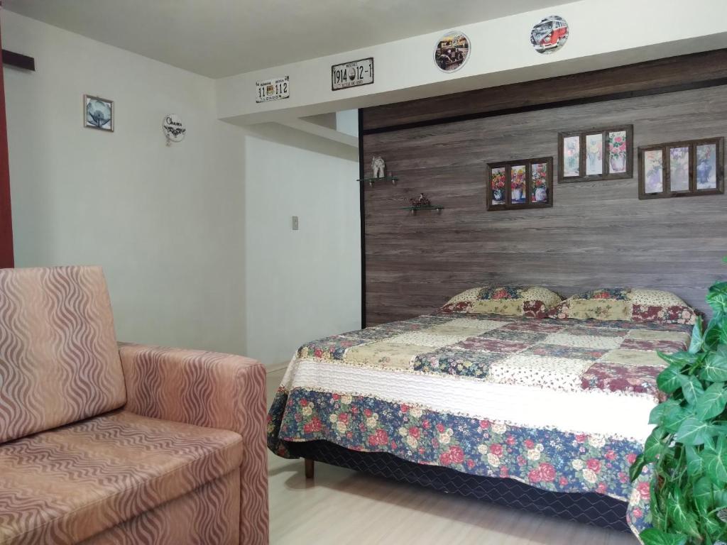 a bedroom with a bed and a chair at Sossego do Interior II in Nova Petrópolis