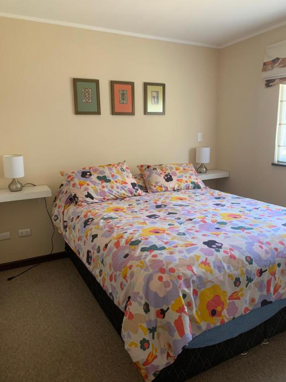 Un dormitorio con una cama con un edredón colorido. en Casa arriendo Pucon, en Pucón