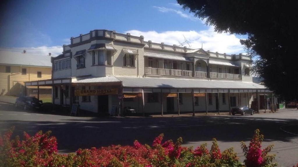 a large white building sitting on the side of a street at Grand Hotel Mount Morgan in Mount Morgan