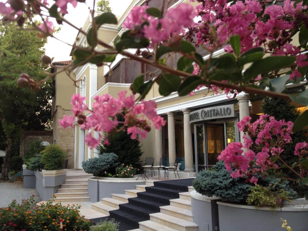 un edificio con fiori rosa di fronte di Hotel Cristallo a Conegliano