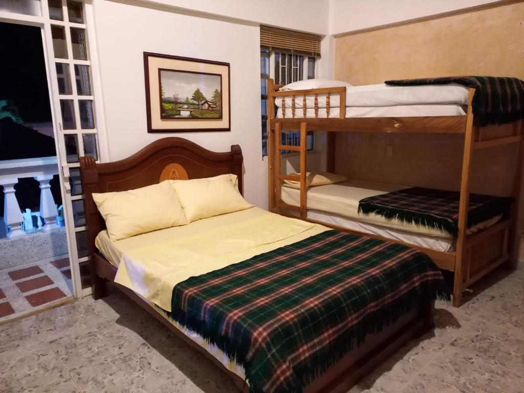 a bedroom with two bunk beds and a bed at Casa Campestre La Colombiana in Montenegro