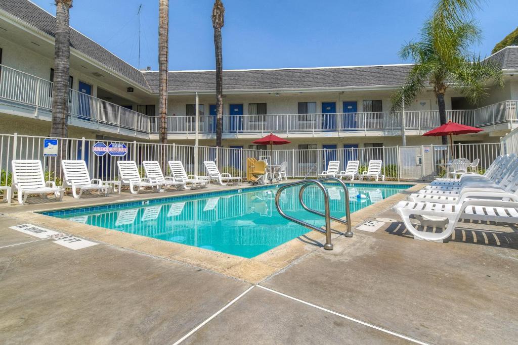 a swimming pool in front of a hotel with chairs at Motel 6-El Cajon, CA - San Diego in El Cajon