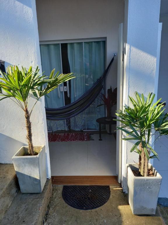 康斯沃托雅的住宿－Suítes Mathias flat，两个盆栽植物坐在门前