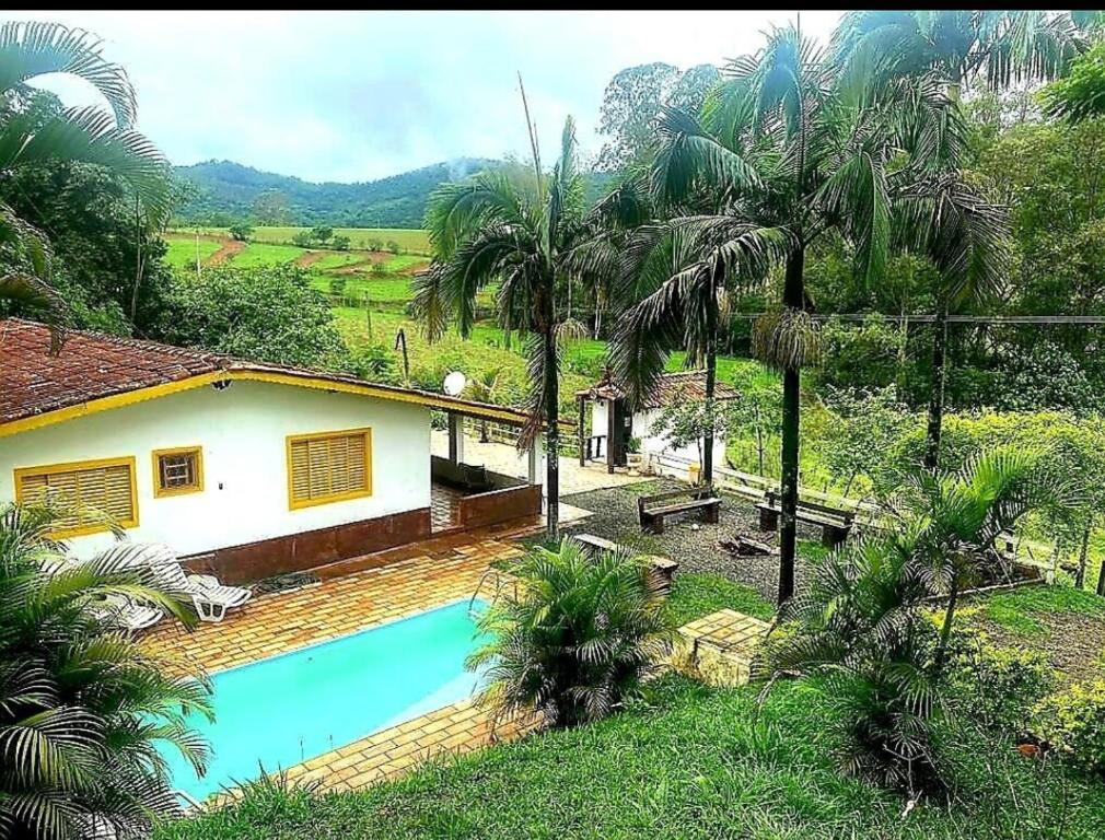 a house with a swimming pool in the yard at Recanto da Natureza in Serra Negra