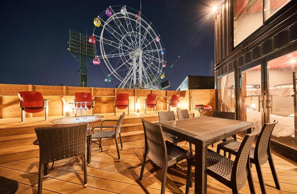 a table and chairs with a ferris wheel in the background at Rakuten STAY x EAGLES 102 with terrace in Sendai