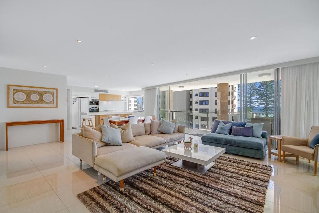 a living room with two couches and a table at Maili 6 Luxury sky home in Gold Coast