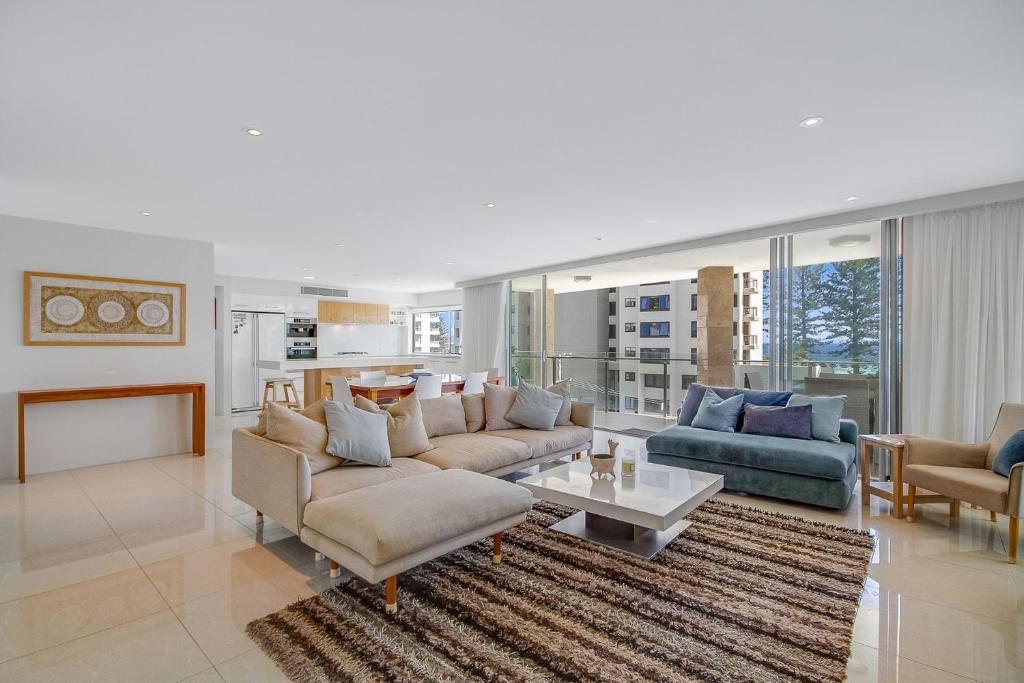 Sala de estar con 2 sofás y mesa en Maili 6 Luxury sky home, en Gold Coast