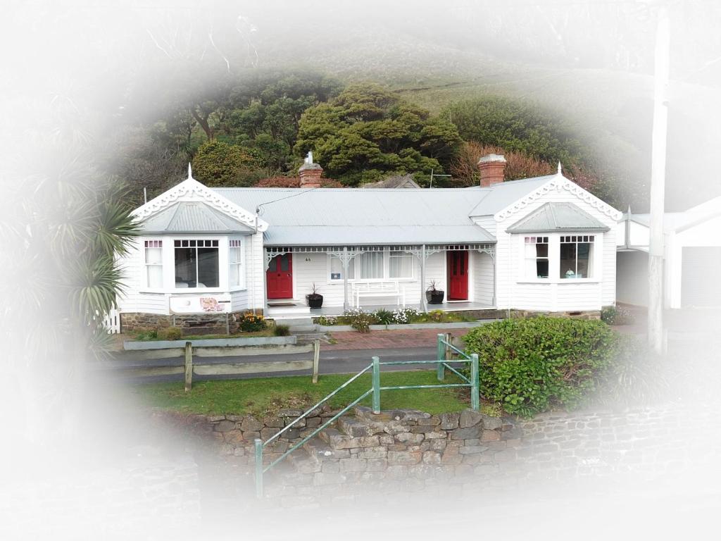 a white house with a hill in the background at Gardenia House in Stanley