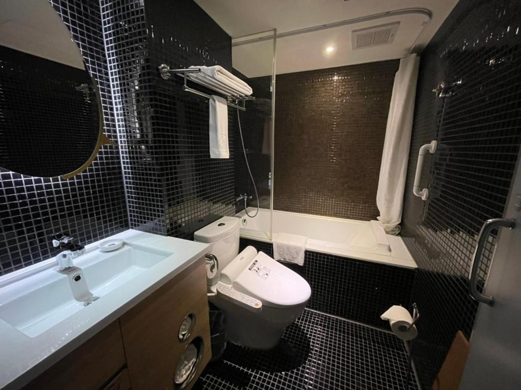 a bathroom with a sink and a toilet and a tub at Simple + Hotel in Taipei