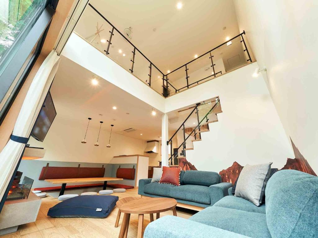 a living room with two blue couches and a table at Rakuten STAY VILLA Hakone Sengokuhara South Wing 104 or 105 BBQ Terrace Pet allowed Capacity of 10 persons in Hakone