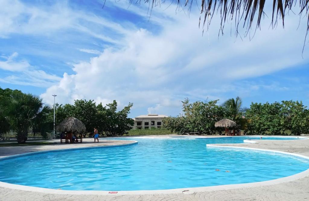 una gran piscina de agua azul frente a un edificio en Bright Apartment at Punta Cana WIFIAcElectIronParking en Punta Cana
