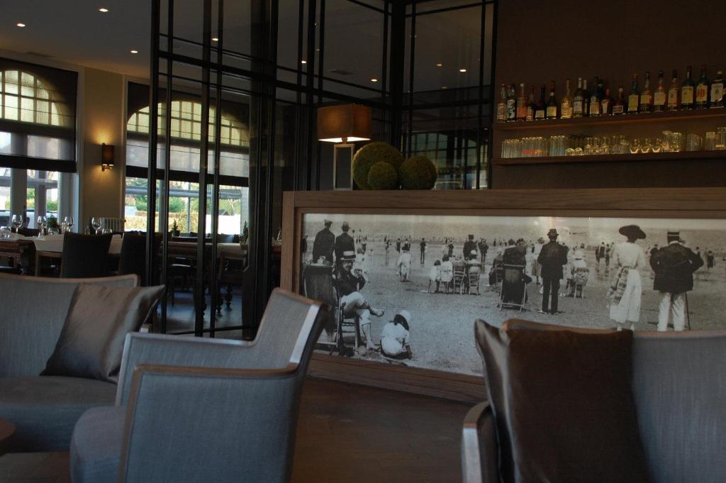 ein Restaurant mit einem Schwarz-Weiß-Foto an der Wand in der Unterkunft Grand Hotel Belle Vue in De Haan