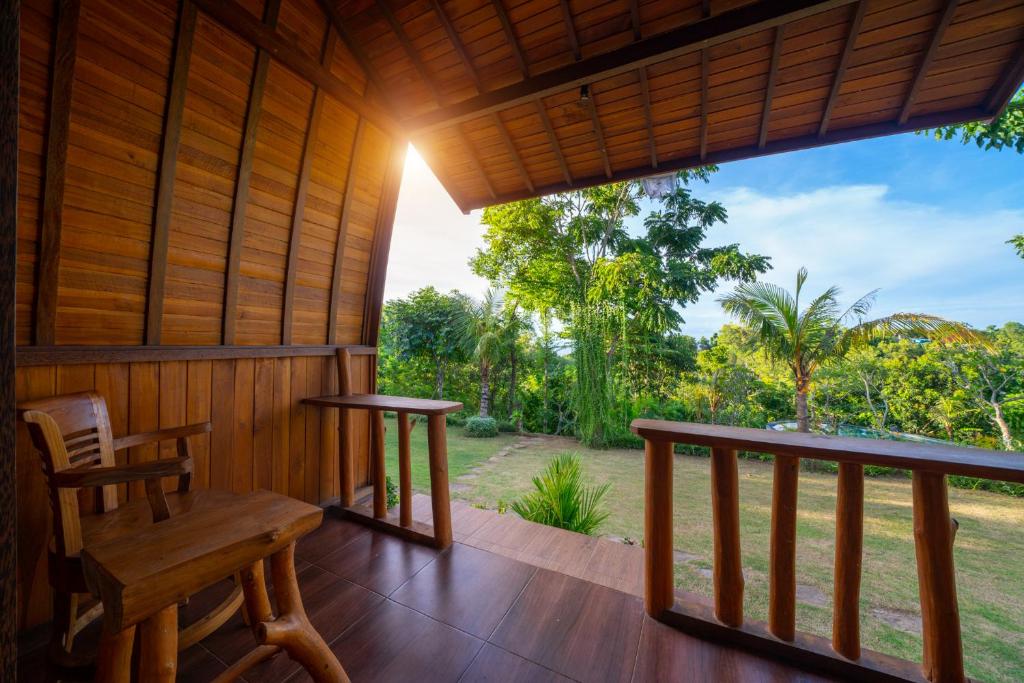 a room with a porch with a table and chairs at Ring Sun Cottages in Uluwatu
