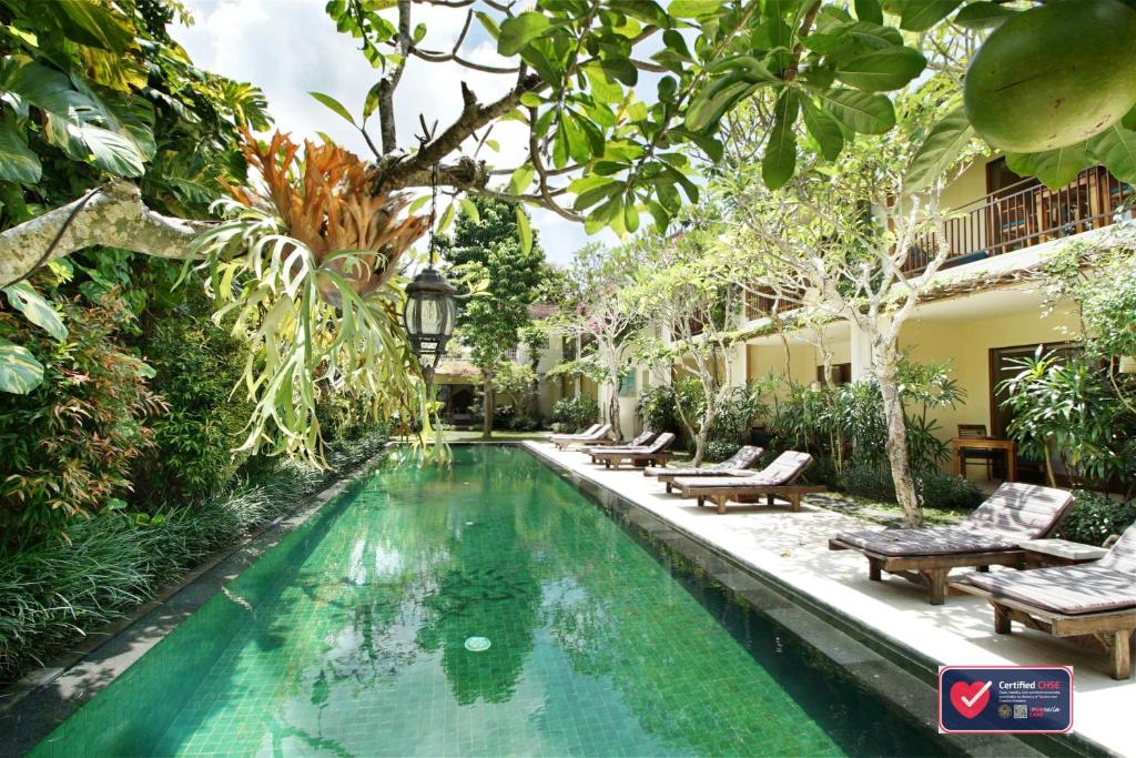 a swimming pool in the middle of a garden at Sapodilla Ubud in Ubud