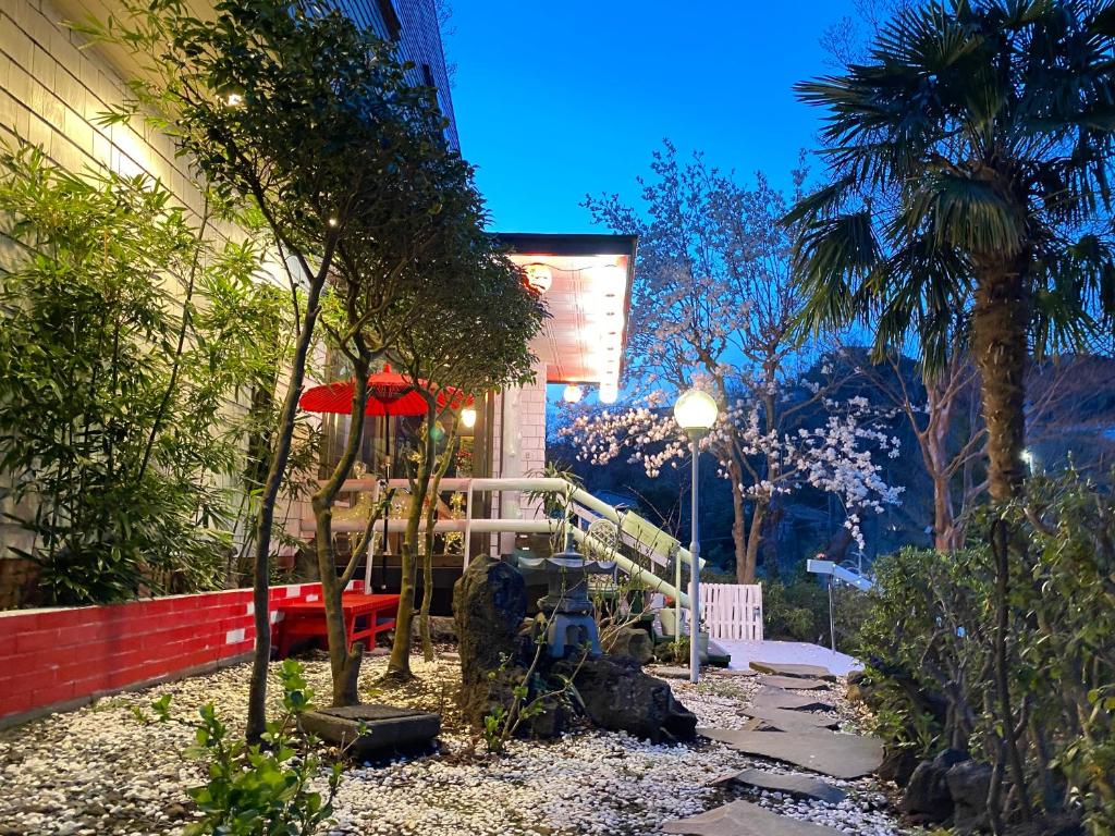 - un jardin avec un banc et un parasol dans l'établissement Hanamizuki Onsen Resort, à Itō