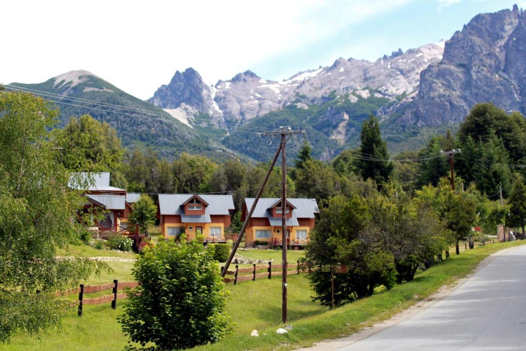 a house on the side of a road with mountains at Cabañas Tierra Sureña in San Carlos de Bariloche
