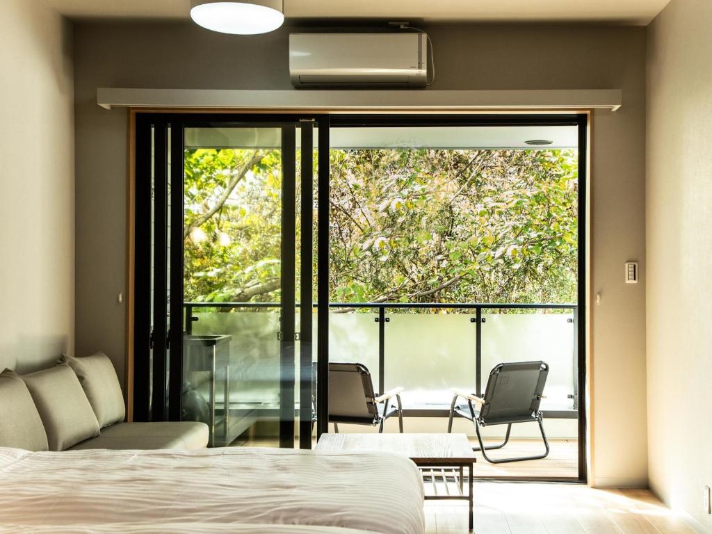 日光市にあるRakuten STAY MOTEL 日光鬼怒川 ドッグフレンドリールームのベッドルーム1室(ベッド1台付)、バルコニー(椅子付)