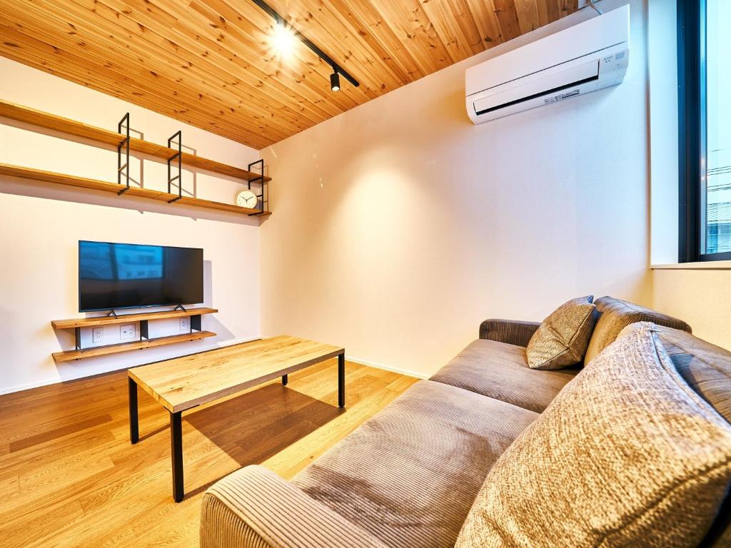 a living room with a couch and a table at Rakuten STAY HOUSE x WILL STYLE Miyazaki Aoshima 102 in Miyazaki