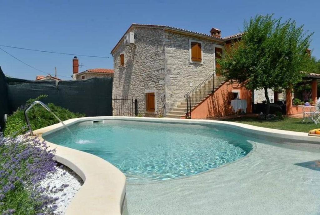 - une piscine en face d'une maison dans l'établissement Rooms Stanza Diniano - with pool, à Vodnjan