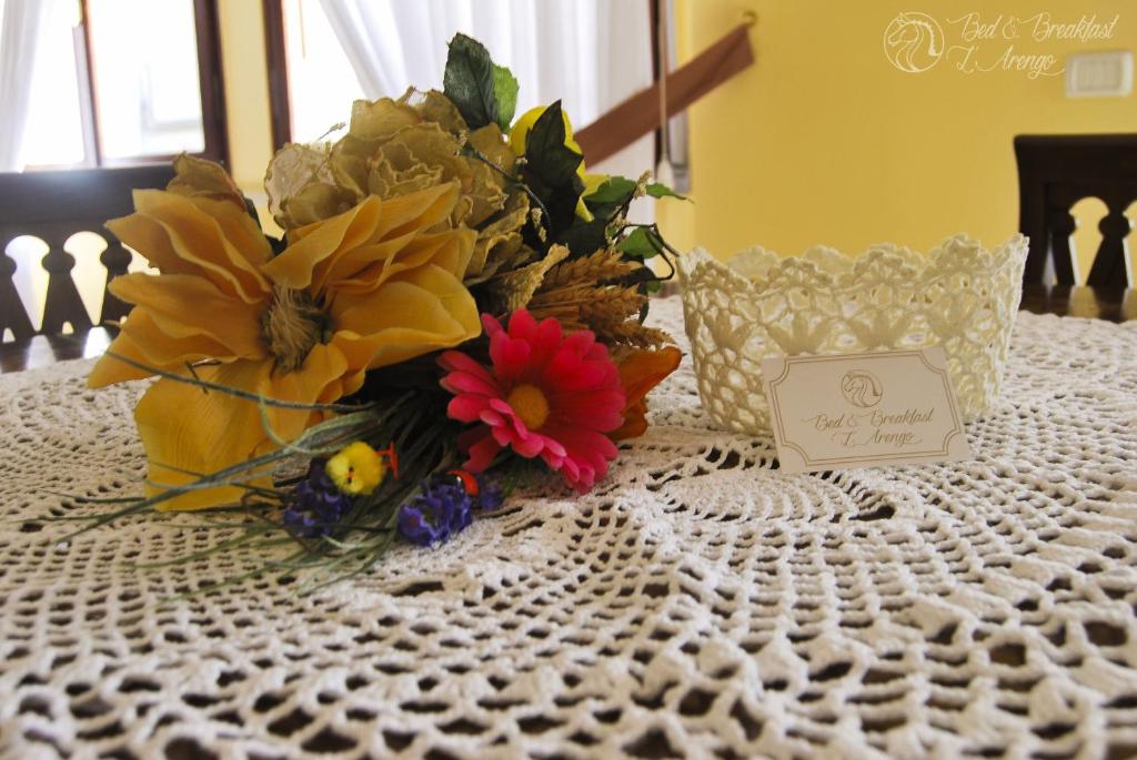 a bouquet of flowers on a table with a card at Bed & Breakfast L'Arengo in Ascoli Piceno