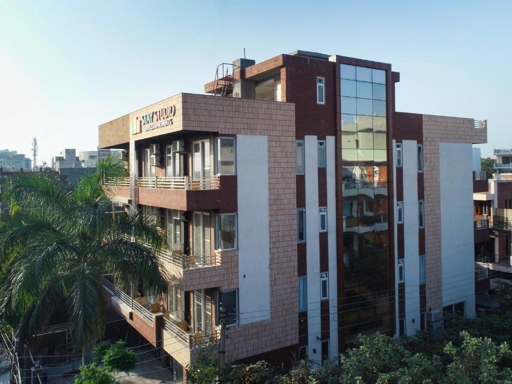 a building with a palm tree in front of it at Stay Studio Hotel &amp; Residences in Gurgaon
