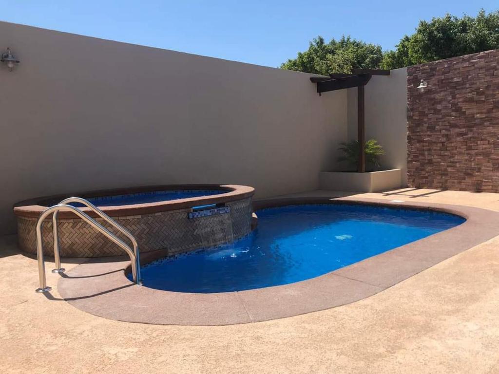 a swimming pool with a hot tub in a backyard at Casa Islas in Puerto Peñasco