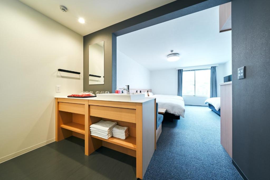 a bathroom with a sink and a bed in a room at Rakuten STAY Osaka Station North Standard Fourth in Osaka