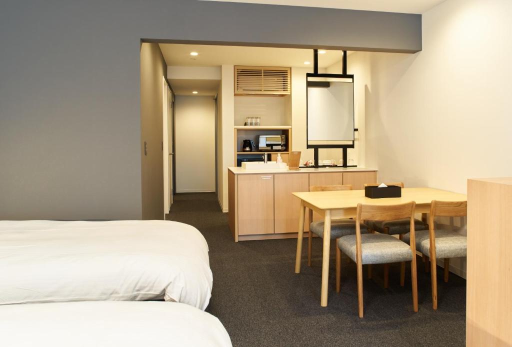 a room with two beds and a table and a kitchen at Rakuten STAY Osaka Station North Deluxe Fourth in Osaka