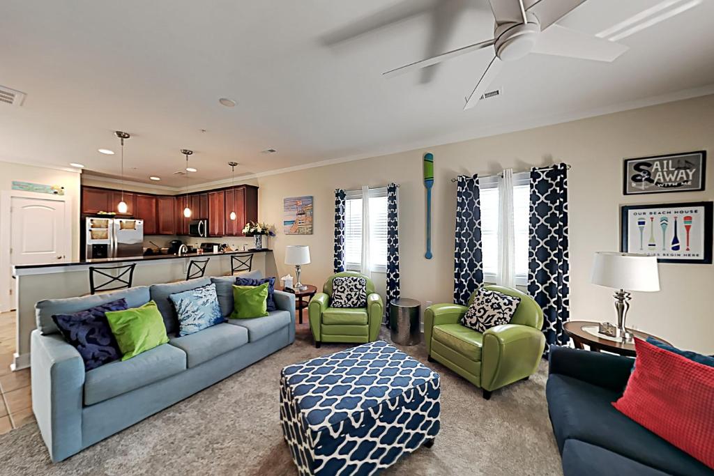 a living room with a blue couch and green chairs at Corals and Oars in Myrtle Beach
