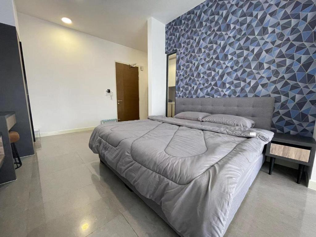 a bedroom with a large bed with a blue wall at Melaka Imperio Residence with Wifi and PoolSeaview in Malacca